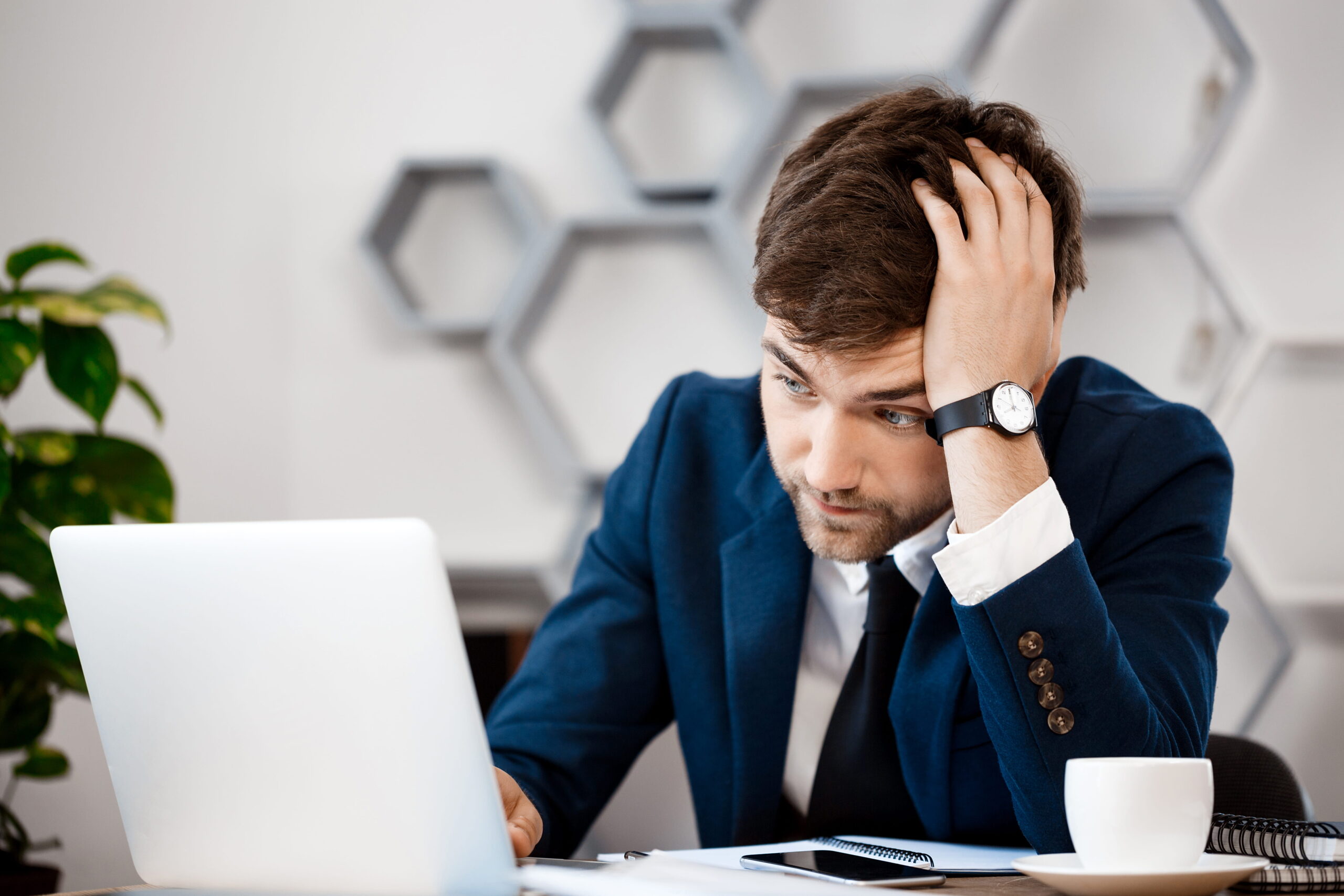 young-businessman-sitting-laptop-office-background